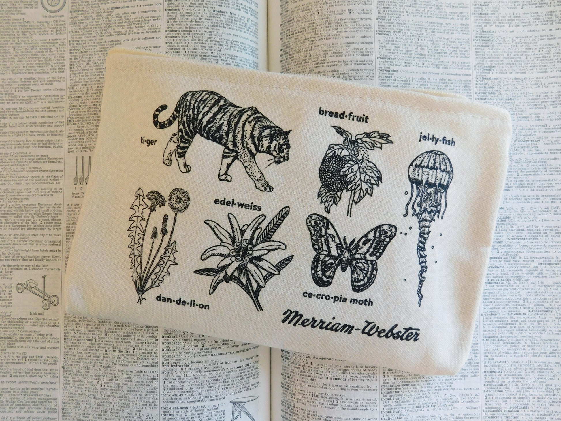 Image of a cotton zip pouch with hand-drawn illustrations of plants and animals paired with their headword, with the Merriam-Webster vintage logo in the lower right.